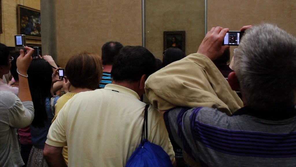 Tourists try and photograph the Mona Lisa