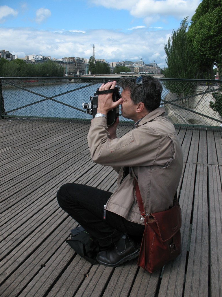 Mark Wihak films with a Bolex camera on the Pont des Arts in Paris. Photo by Wanda Schmöckel.